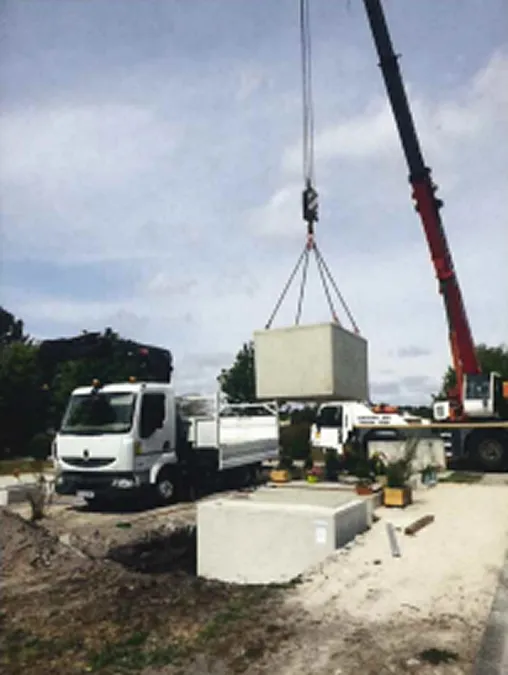 Levage d'un caveau en béton à l'aide d'une grue dans un cimetière, intervention par Aquitaine Marbrerie